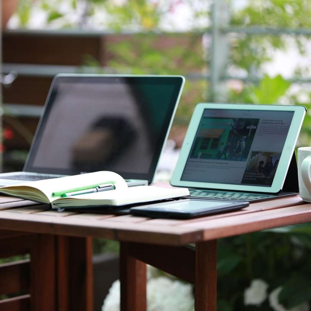 un tablet di fianco ad un notebook