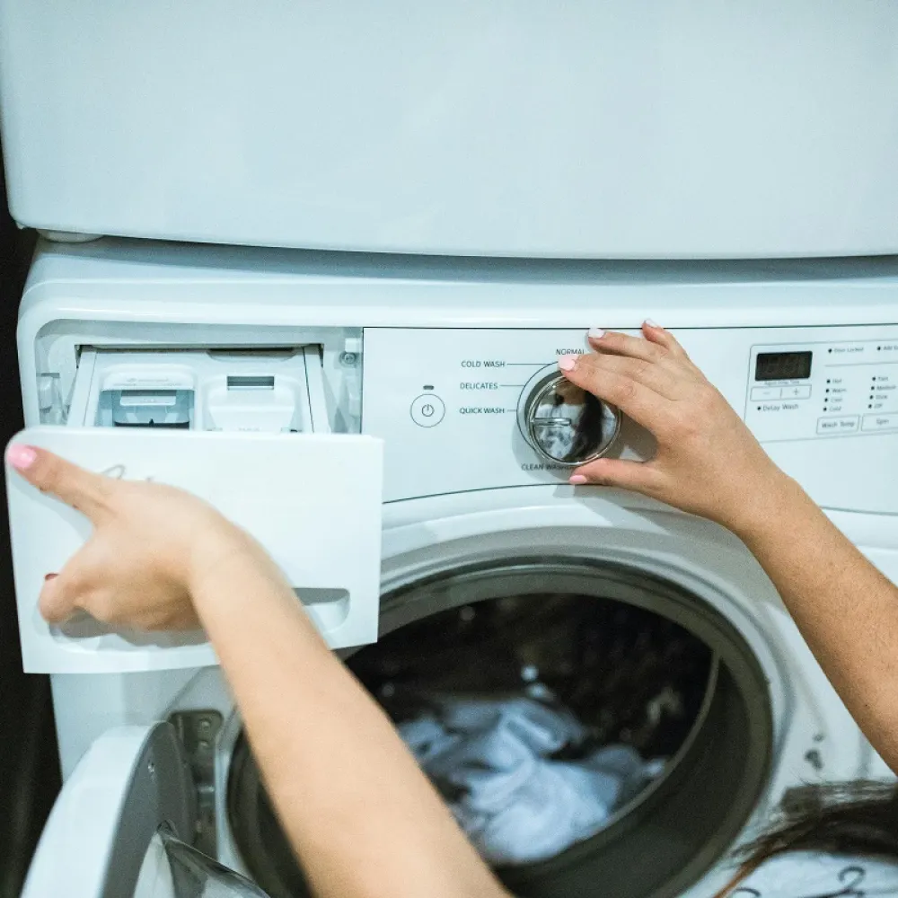 una casalinga sta caricando la lavatrice per il bucato