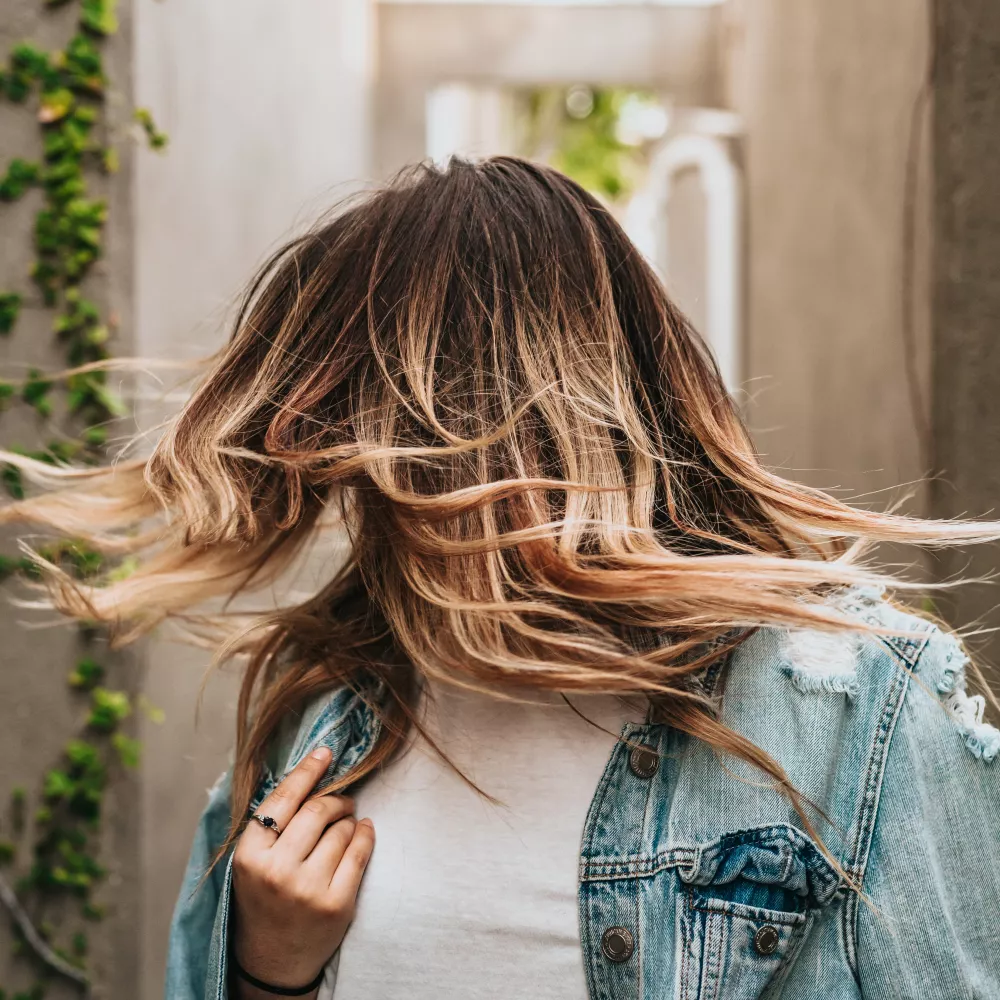 una donna che mostra la sua folta capigliatura: senza danni termici ai capelli
