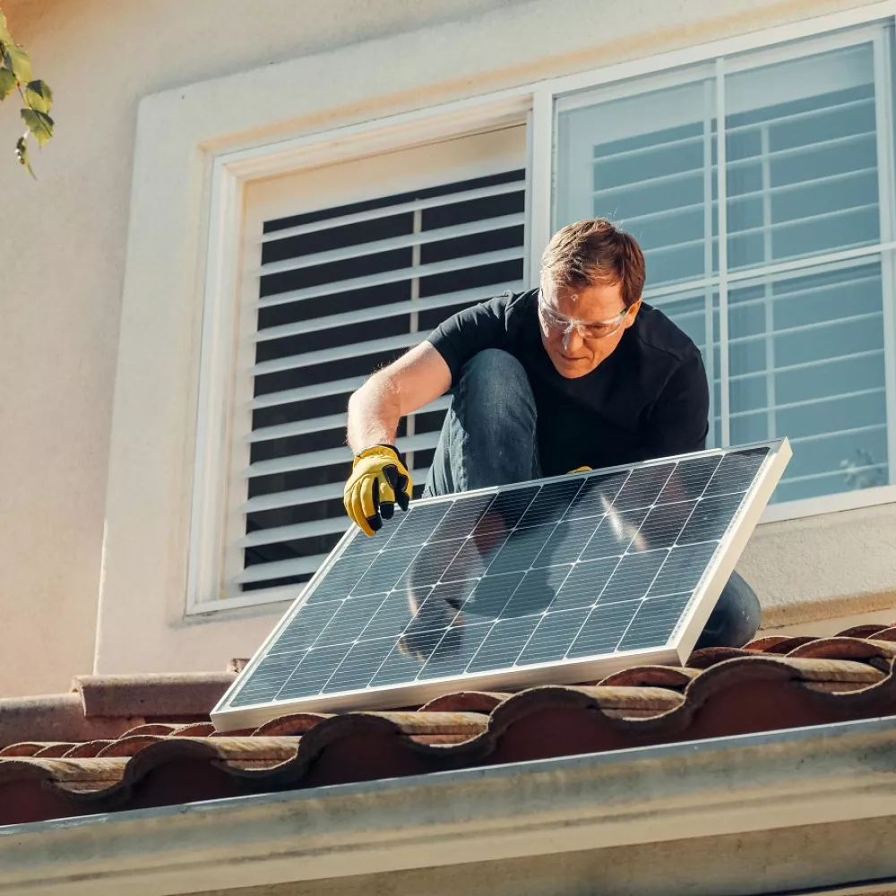 un operaio sta procedendo con la connessione dei pannelli solari alla rete domestica