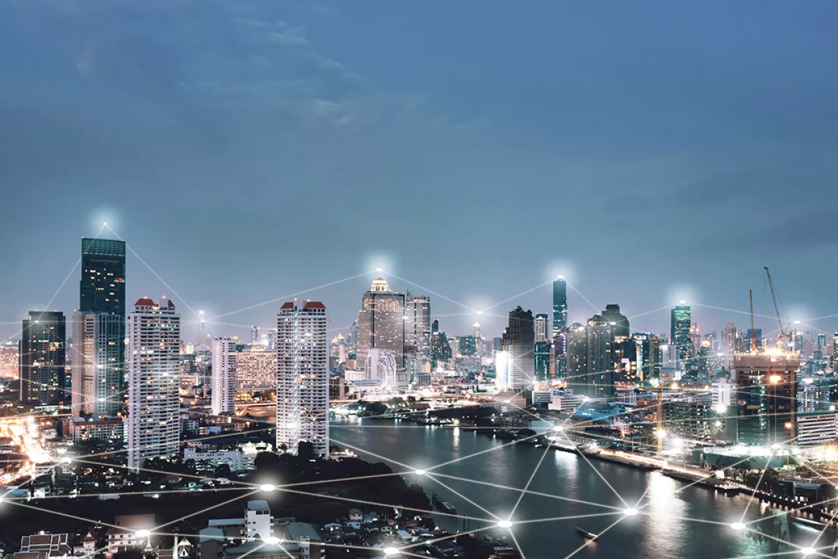 Bird's-eye view of a city with a river at night, in which many points are virtually connected by lines.