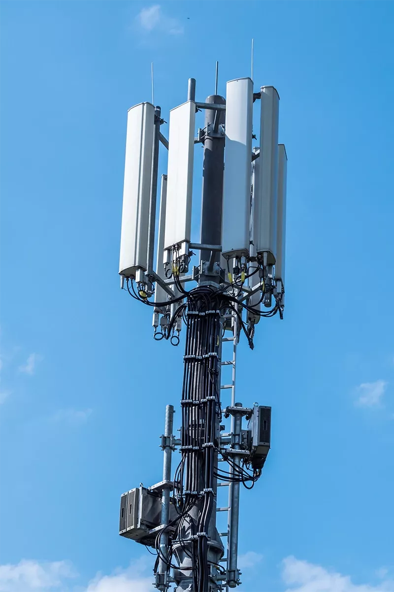 Mobilfunkmast mit Antennen vor blauem Himmel
